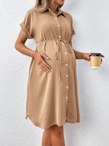 Detail view of a stylish khaki maternity shirt dress with short sleeves and a belted waist