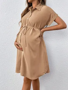 Close-up of khaki maternity shirt dress with drawstring waist and button front detail