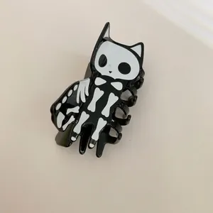 Detailansicht einer lustigen schwarz-weißen Skelett-Katzen-Haarklammer für Halloween
