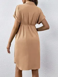 Back view of a khaki short sleeve maternity shirt dress featuring a waist tie detail