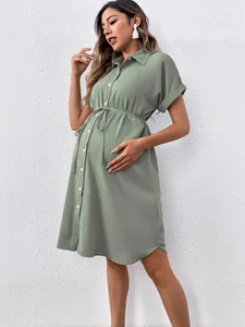 Stylish sage green short sleeve maternity shirt dress with button-front and adjustable tie waist.