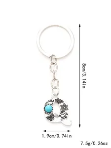 Detailed view of an alloy letter Q keychain featuring a turquoise bead and floral designs