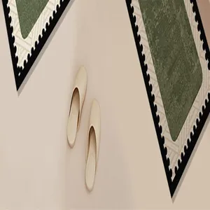 Detailed view of an L-shaped absorbent bathroom mat featuring a green and black border