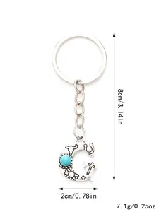 Detailed view of western style G-letter keychain with turquoise and dimension markings