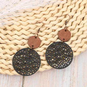 Orecchini pendenti vintage boho in legno traforato e pelle con maglia circolare.