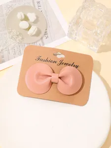 Detailopname van een roze lederen strik haarspeld op een displaykaartje