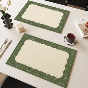 Elegantes manteles individuales verdes estilo retro francés sobre mesa blanca con té