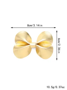 Detailweergave van gouden leren strik haarspeld met afmetingen: 8 cm breed en 6 cm hoog