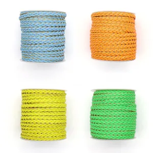 Detailed view of four colorful braided PU leather cords on white spools for DIY crafts