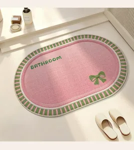 Detailed view of pink linen braided bathroom mat with green bow and bathroom embroidery text