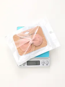 Gedetailleerd zicht op een roze lederen strikhaarclip op een weegschaal van 9,1 gram