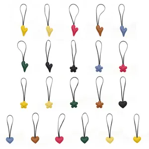 Collection of colorful leather heart and flower charms for bag and keychain DIY accessories.