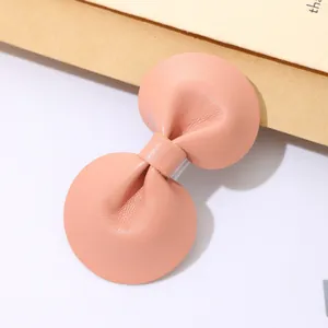 Elegante perzikkleurige lederen strik haarclip met een getextureerde afwerking