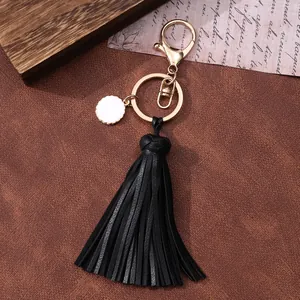 Elegante llavero de borla de cuero negro con cierre de mosquetón dorado y colgante