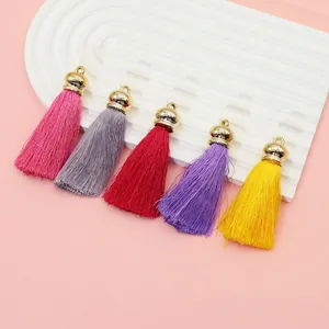 Detail view of colorful polyester tassels with golden crown caps for DIY jewelry crafts