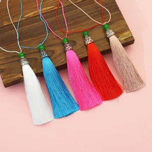 Detailed macro view of colorful polyester tassels with decorative silver caps and green beads