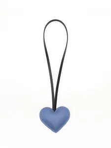 Detailed view of a cute blue leather heart-shaped bag charm with black strap