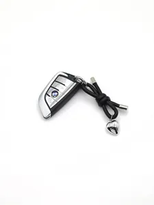 Detail of black braided leather keychain with silver heart charm on car key