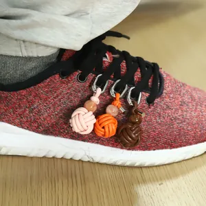 Close-up of hand-woven PU spherical charms used as decorative shoe lace accessories