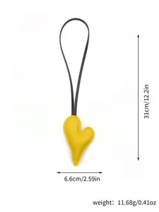 Detailed size and weight view of a yellow leather heart bag charm with black strap