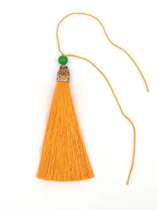 Macro detail of high-quality orange polyester tassel with green bead and silver cap