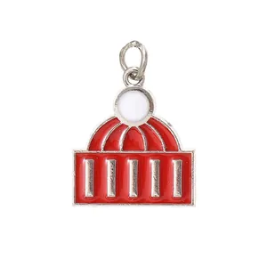 Detail shot of a red enamel building-shaped jewelry charm with silver-toned metal accents.