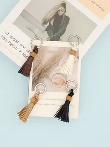 Close-up of handmade PU leather tassel keychains with wooden beads in four colors.