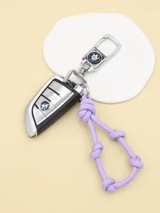 Detail view of a purple knotted leather lanyard attached to a premium car key fob.