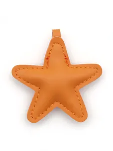 Detailed view of the orange star-shaped leather charm featuring visible stitching details.