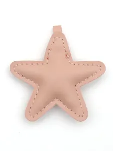 Close-up view of the star-shaped pink leather bag charm with decorative stitching.