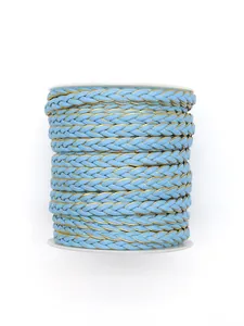 Detail macro view of sky blue and gold braided PU leather cord roll for DIY crafts