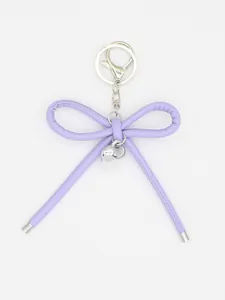 Close-up of minimalist purple leather bow keychain with silver heart pendant ornament