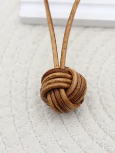 Detailed close-up of a handmade vintage leather woven monkey fist knot keychain pendant.
