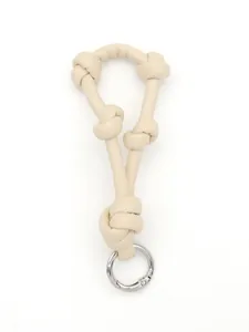 Detail view of beige knotted leather lanyard bag charm with a silver metal spring ring