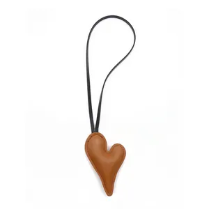 Minimalist brown heart-shaped leather bag charm with thin black strap for stylish accessories