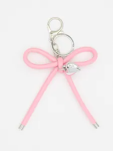 Detail view of pink leather bow keychain with silver heart charm and lobster clasp