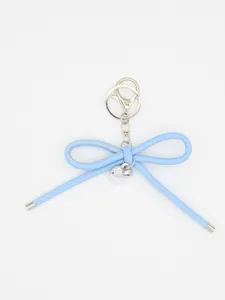 Close-up of blue woven leather bow keychain with silver heart charm and lobster clasp
