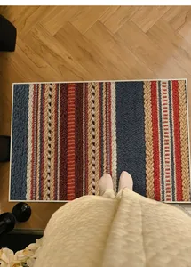 Detalle de cerca del felpudo de rayas bohemias con textura de bucle en suelo madera
