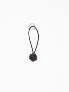 Close-up of handmade dark brown leather monkey fist knot keychain charm with silver ring