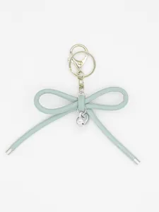 Close-up of a Morandi blue leather bow keychain with a shiny silver heart charm.