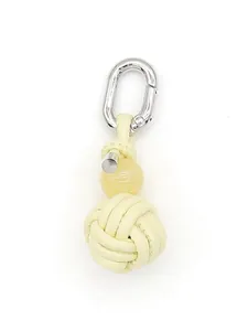 Detailed view of hand-woven cream PU leather knot ball keychain with silver clasp