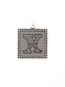 Close-up of vintage silver alloy square pendant with ornate letter X engraving