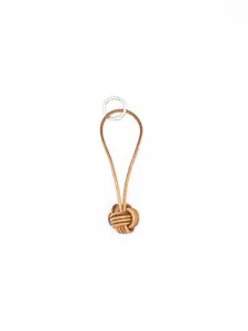 Macro detail of a handwoven brown leather monkey's fist knot keychain with silver ring