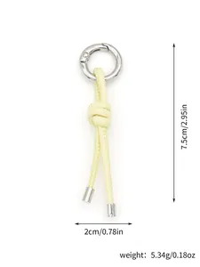 Detail view of handmade yellow knotted leather keychain showing size and weight specs