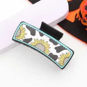 Detaillierte Makroaufnahme von Western-Kuhmuster und Sonnenblumen-Haarklammer für Damen.