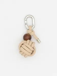 Close-up detail of a beige handmade woven PU ball keychain with a silver metal carabiner