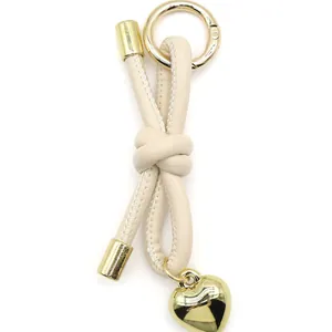 Beige knotted leather keychain with gold heart charm for bags and keys