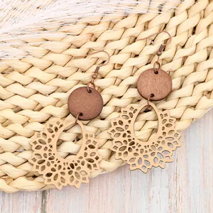 Close-up of bohemian hollow wood earrings with intricate laser-cut floral patterns.