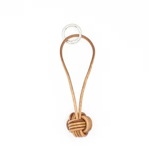 Handmade vintage leather monkey fist knot keychain with silver ring on white background