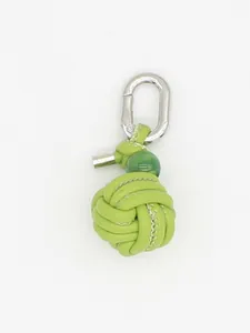 Close-up of lime green handcrafted woven leather ball keychain with silver carabiner